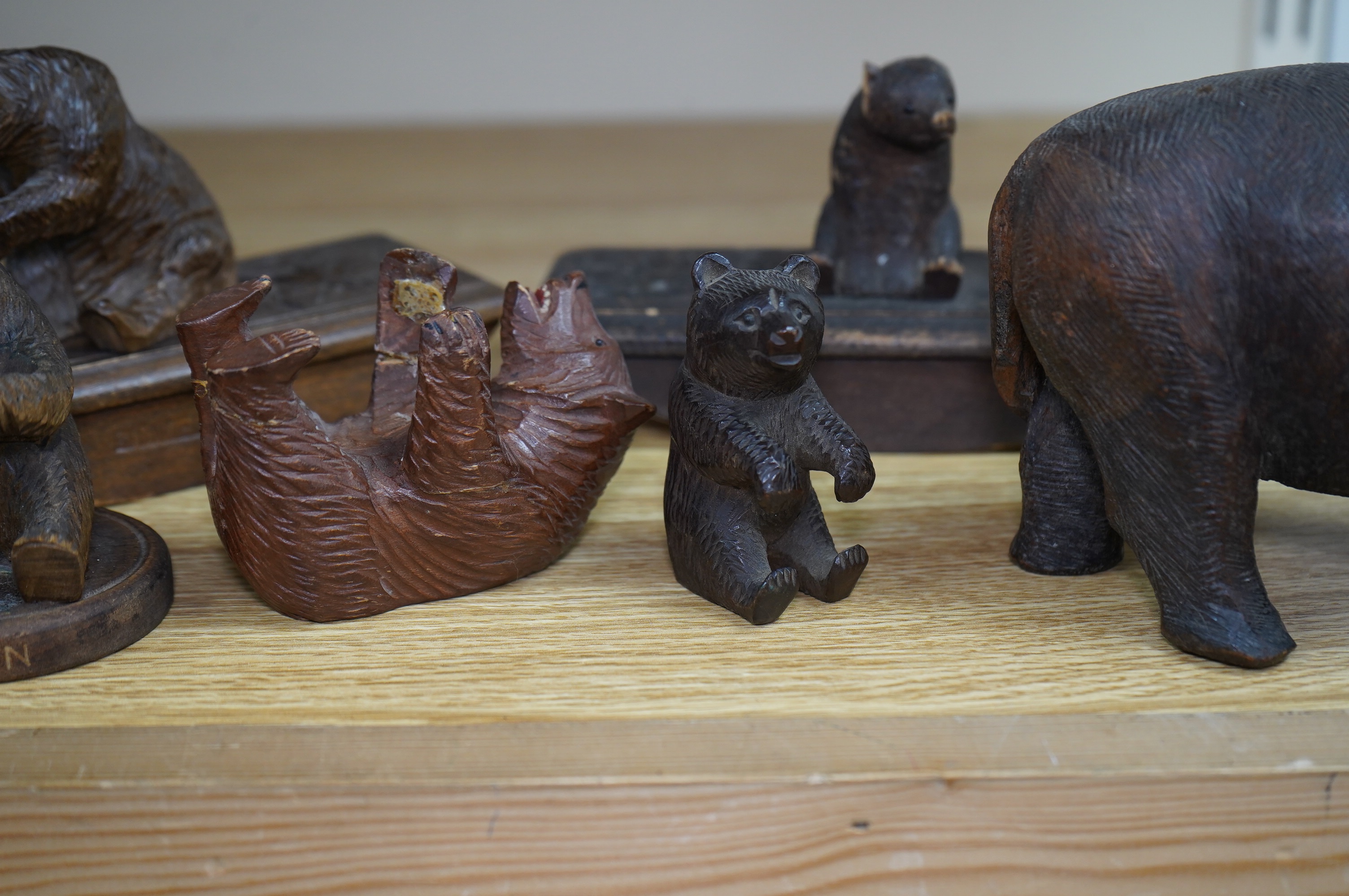 Five carved Black Forest bears, two in the form of ink blotters, together with an African figure of a hippopotamus, largest 17cm wide. Condition - poor to fair